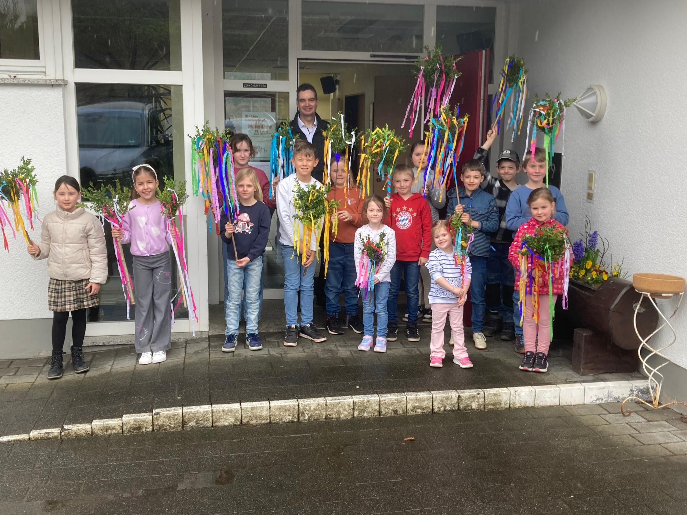Stolz präsentiert ein Teil der Kinder die fertigen Palmstöcke